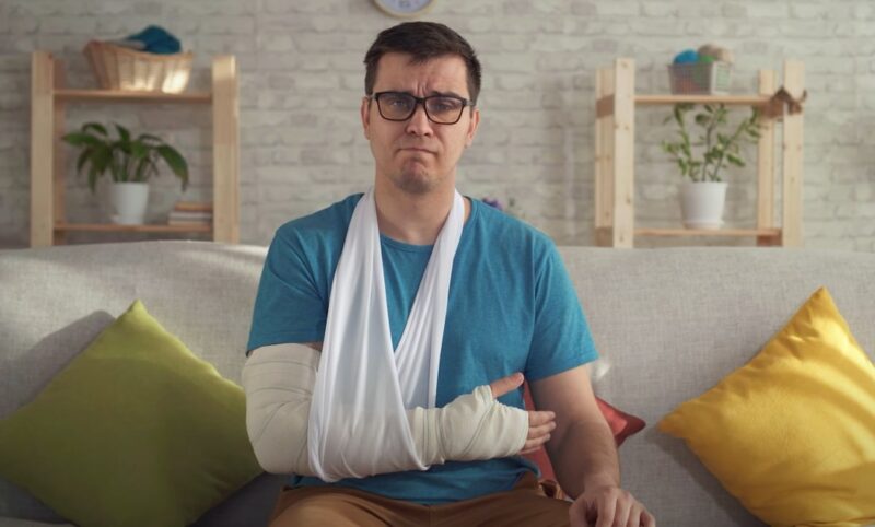 An injured young man with a bandaged arm after a car accident