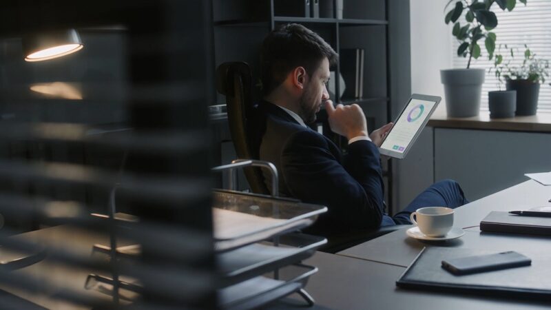 A focused lawyer sitting at a desk, engaging with legal learning software on a tablet